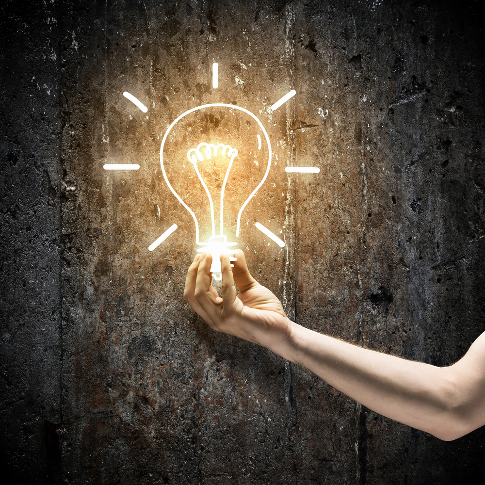 Close up image of human hand holding electrical bulb in darkness Close up image of human hand holding electrical bulb in darkness